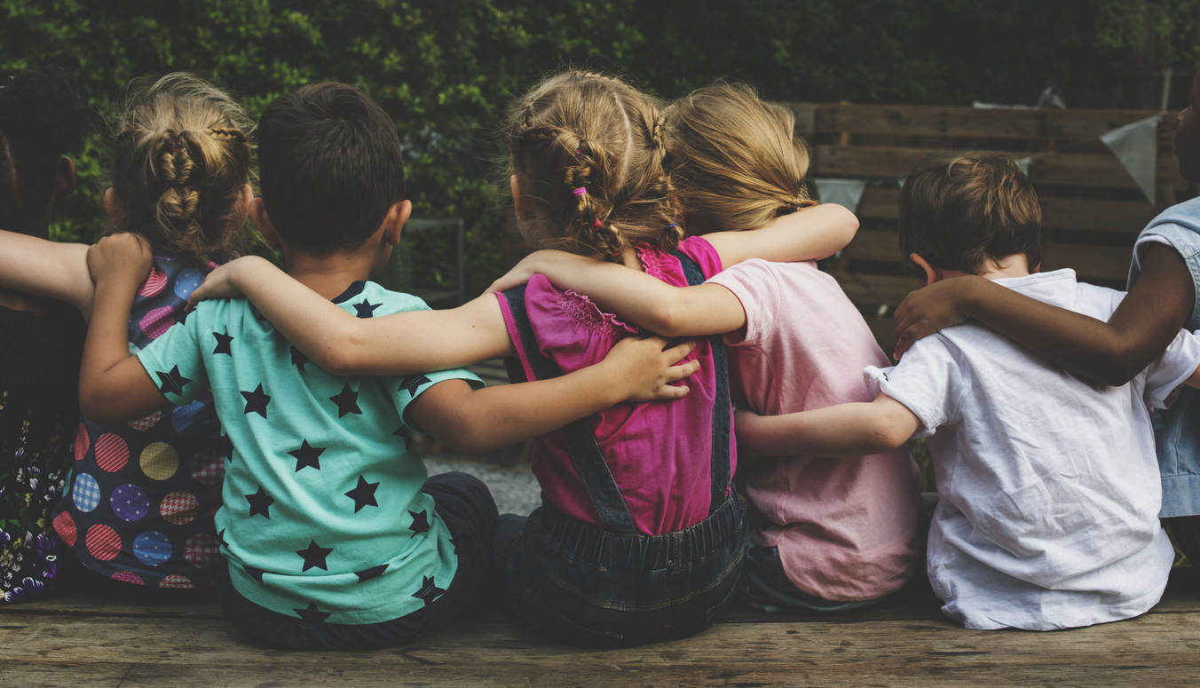 Children sitting together with arms around each other